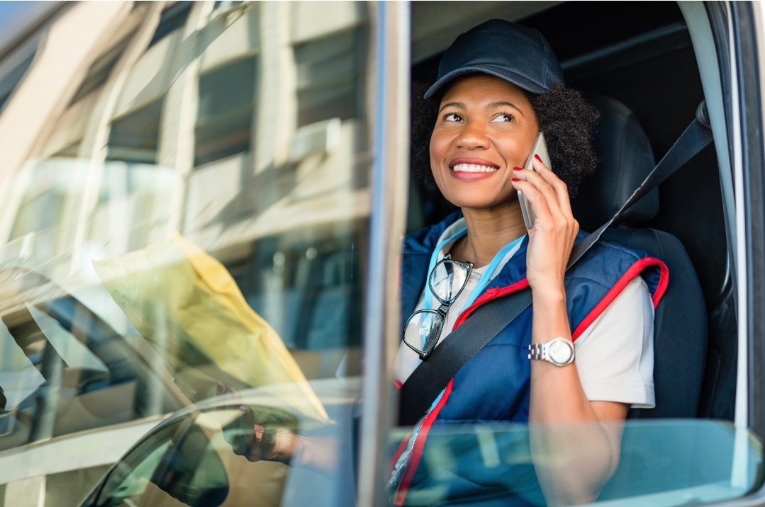 Delivery driver in a van speaking with a customer on the phone