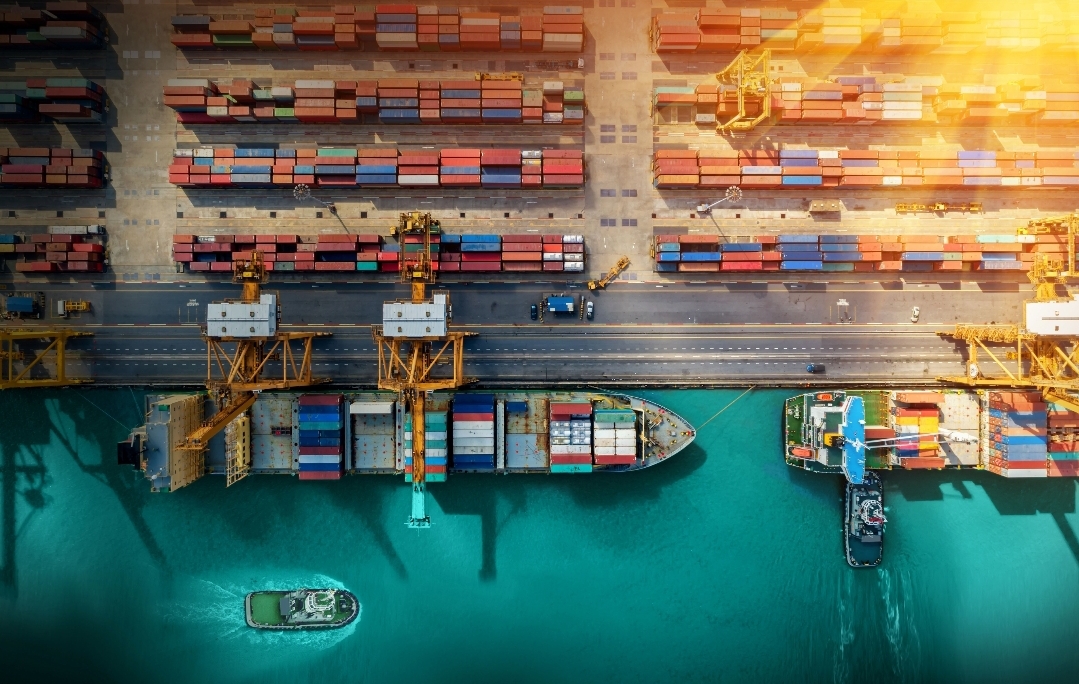 Aerial view of a container port with cargo ships being loaded by cranes